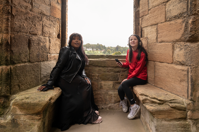 Linlithgow Scots Audio Guide: Laura Lovemore, a professional Scottish actor who provides the voice of Margaret More, one of the women known in the records as the ‘Moorish Lassies’, listening to the new Scots audio guide at Linlithgow Palace with Martha who voices the young Princess Elizabeth, daughter of James VI & Anna of Denmark.