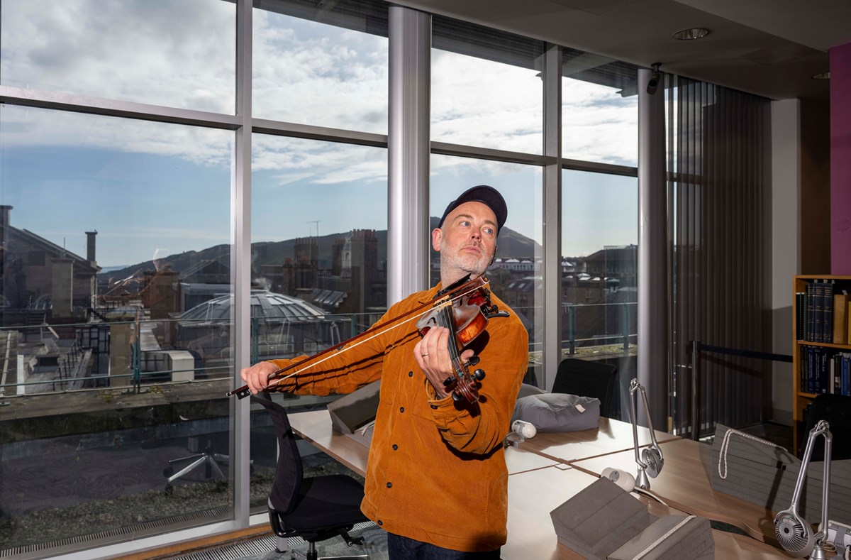 Fiddler Aidan O'Rourke in the Special Collections Reading Room, situated on the top floor of the National Library of Scotland's George IV Bridge building. Credit: Neil Hanna