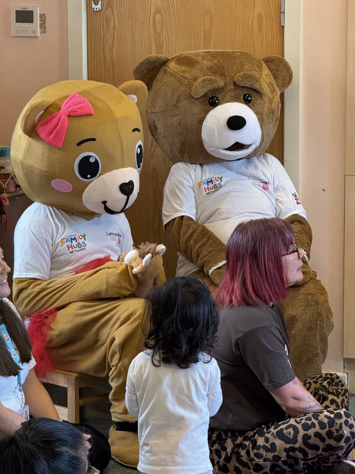 A little girl enjoys the giant teddy bears at the teddy bears' picnic at Ribbleton Family Hub