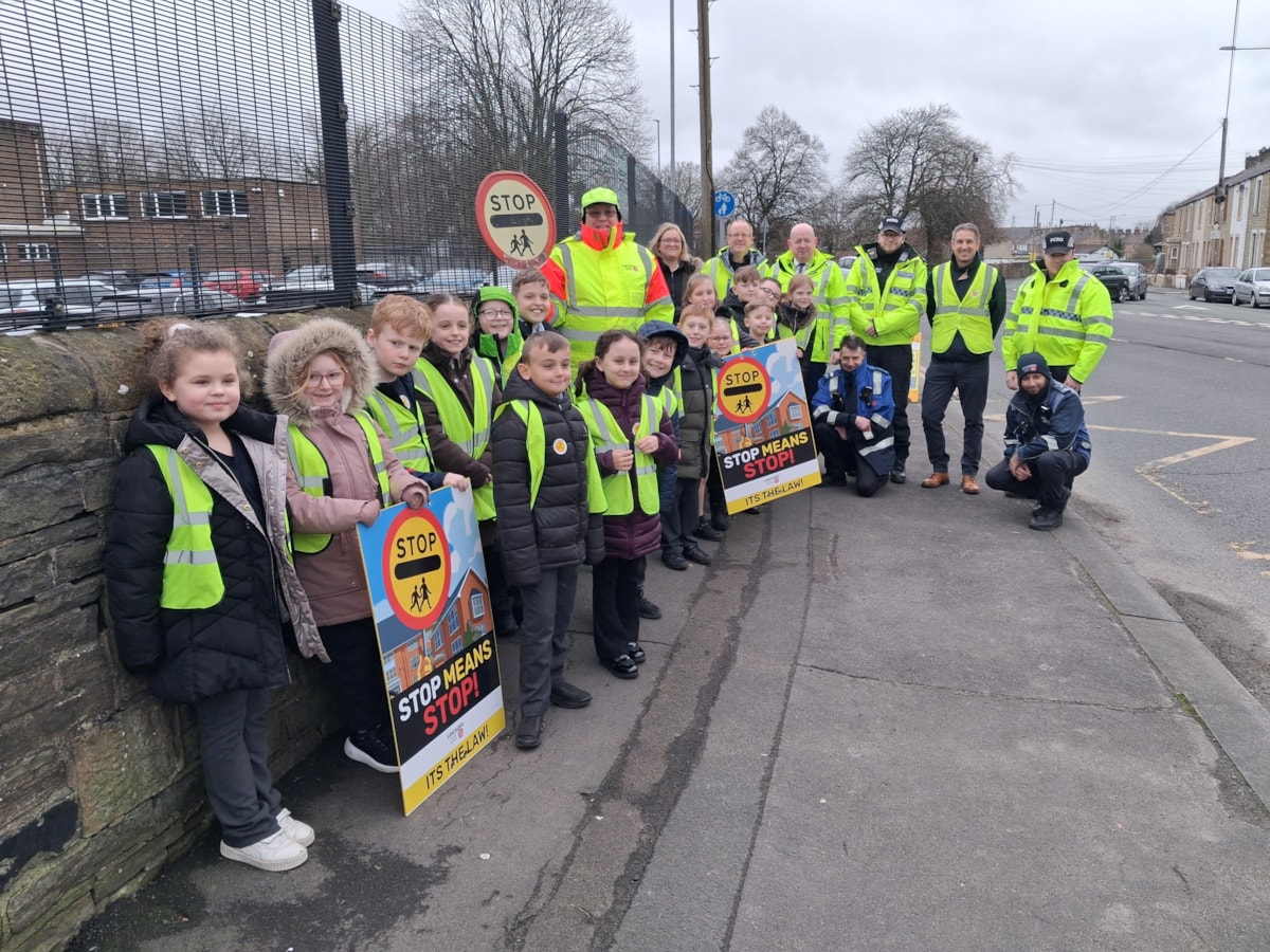 Youngsters from Lowerhouse Junior School, Lancashire County Council's Executive Director, Phil Green and road safety officers, School Crossing Patrol Officer Michael Taylor and PCSOs Jordan and Ashley on the day of action in Burnley