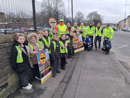 Youngsters from Lowerhouse Junior School, Lancashire County Council's Executive Director, Phil Green and road safety officers, School Crossing Patrol Officer Michael Taylor and PCSOs Jordan and Ashley on the day of action in Burnley