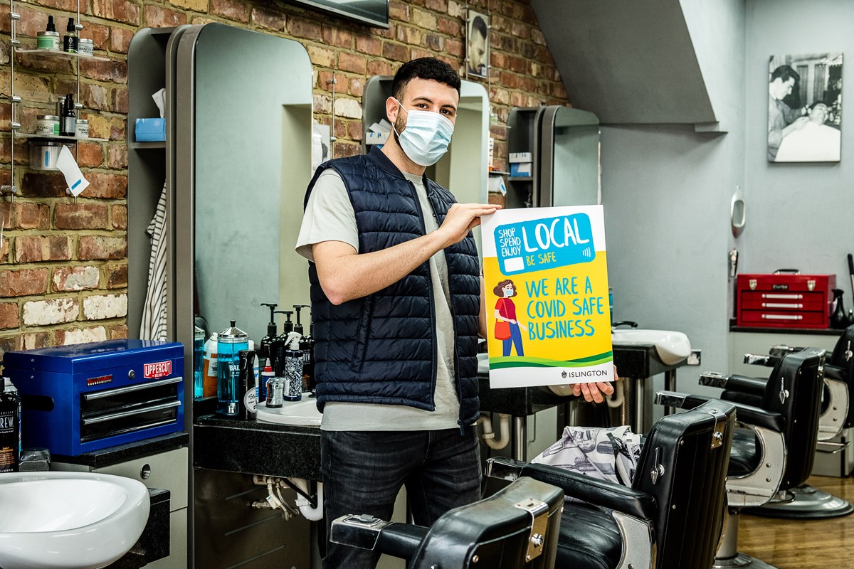 Pas Bertolino, of Stasi Barbers & Academy in Junction Road, Archway, promoting the Covid-Safe Business Award scheme window stickers