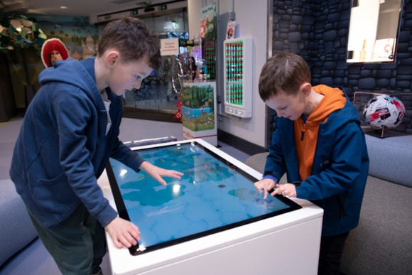 Children playing interactive games in the new LNER Family Lounge at Edinburgh Waverley