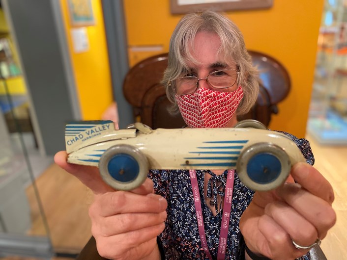 Abbey House toy display: Kitty Ross, Leeds Museums and Galleries' curator of social history with a toy racing car from the 1930s modelled after Bluebird, the vehicle which set the land speed record in 1927 when it was driven by Malcolm Campbell.