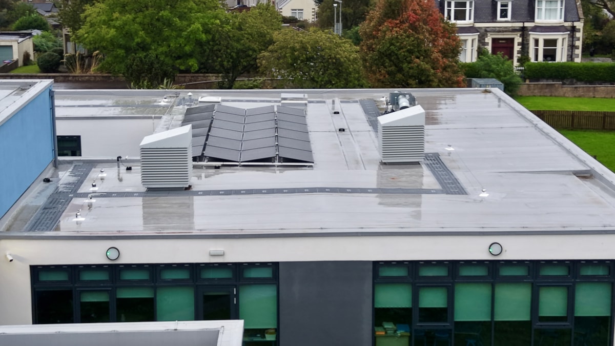 Aerial view of the upgraded roof at Cullen Primary School, showing newly installed solar panels and ventilation equipment.
