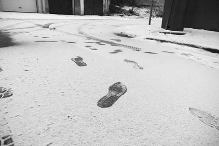 Footprints on snowy road - 923463082