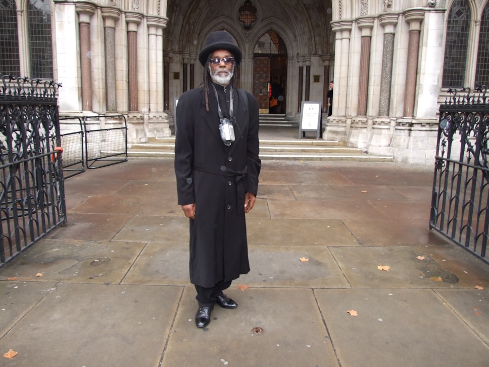 Sir Collins stands outside London’s High Court in 2004 after a New Cross Fire inquest hearing.