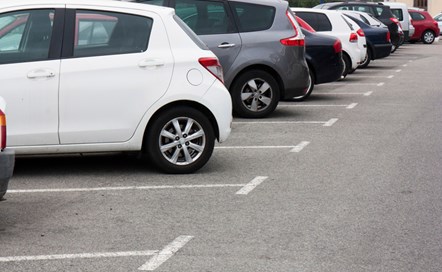 Cars are lined up diagonally in an outdoor car park.