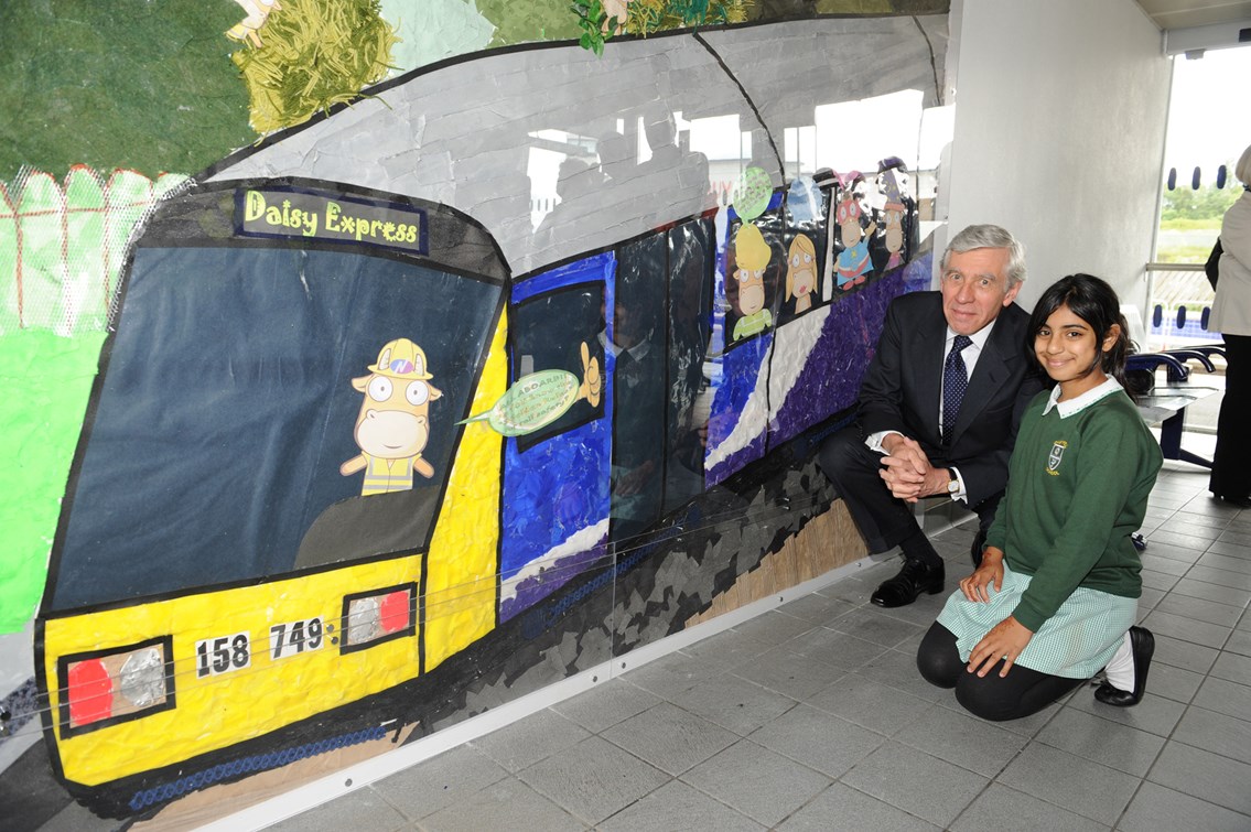 Rt Hon Jack Straw MP at Blackburn station: Jack Straw MP and Sana Ali from Daisyfield Primary School kneeling in front of artwork produced by the school and now exhibited in the waiting room on platforms 1/2. (24 June 2011)