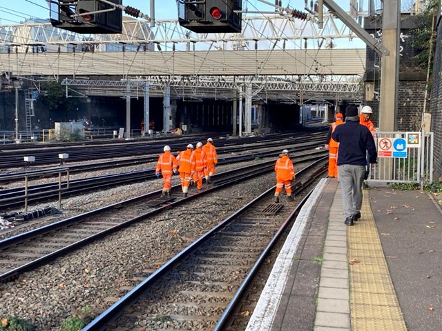 Network Rail engineers walking along the track to scene of overhead line damage at Euston