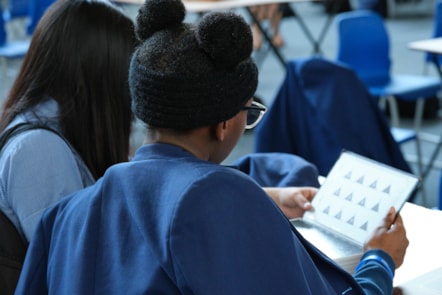 Two students seen from the back from All Saints Catholic High School taking part in escape games offered as part of the Homerton for Homerton programme, 2024 (credit Suzanne Mitchell)