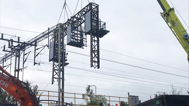 Old signalling gantry being lifted out by crane in Macclesfield