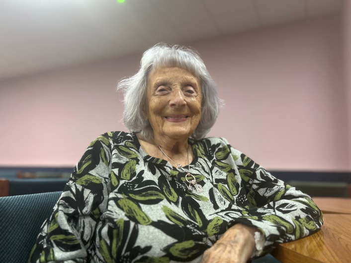 Rita Green - D Day event: Rita is pictured smiling at the camera, sitting at a table.