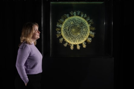 Injecting Hope Curator Sophie Goggins with 2020: The Sphere that Changed the World by Angela Palmer. The artwork is on display in Injecting Hope, a new exhibition at the National Museum of Scotland.

Photo ©  Stewart Attwood