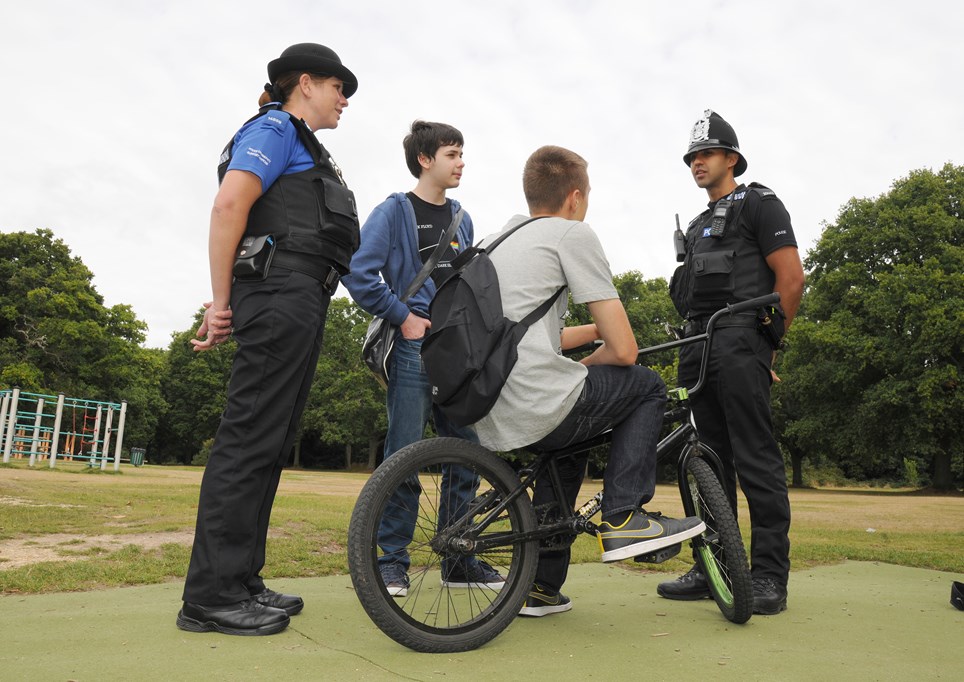 Police officer and PCSO engaging with two children.