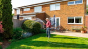 Picture of a man watering his back garden on a sunny day: Picture of a man watering his back garden on a sunny day