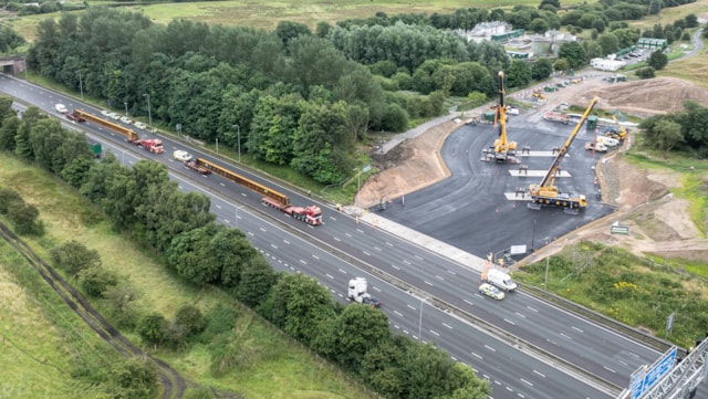 Network Rail reveals drone footage of 42 metre beam delivery ahead of multi-million-pound bridge rebuild over the M62.: Aerial view of the beams entering the work site