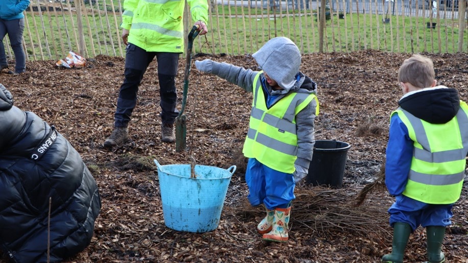 One of the young pupils dips a tree