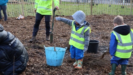 One of the young pupils dips a tree