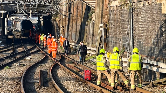 London Euston station overhead line damage causing major delays: Network Rail teams and emergency services helping passengers off stranded train outside Euston station