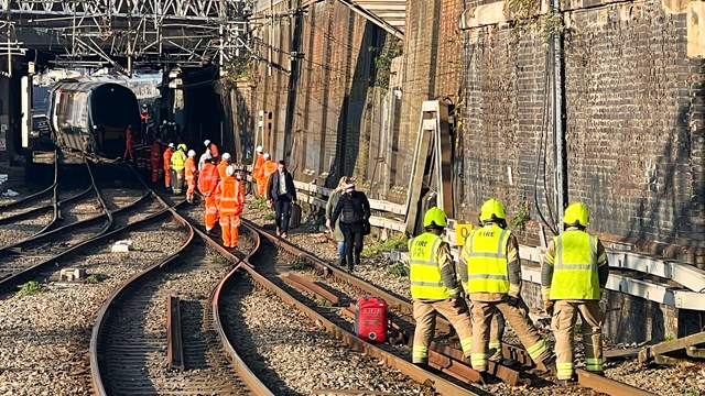 Network Rail teams and emergency services helping passengers off stranded train outside Euston station