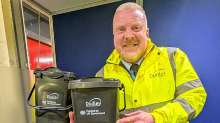 Cllr Damian Corfield with the new blue recycling bin and caddies for food waste