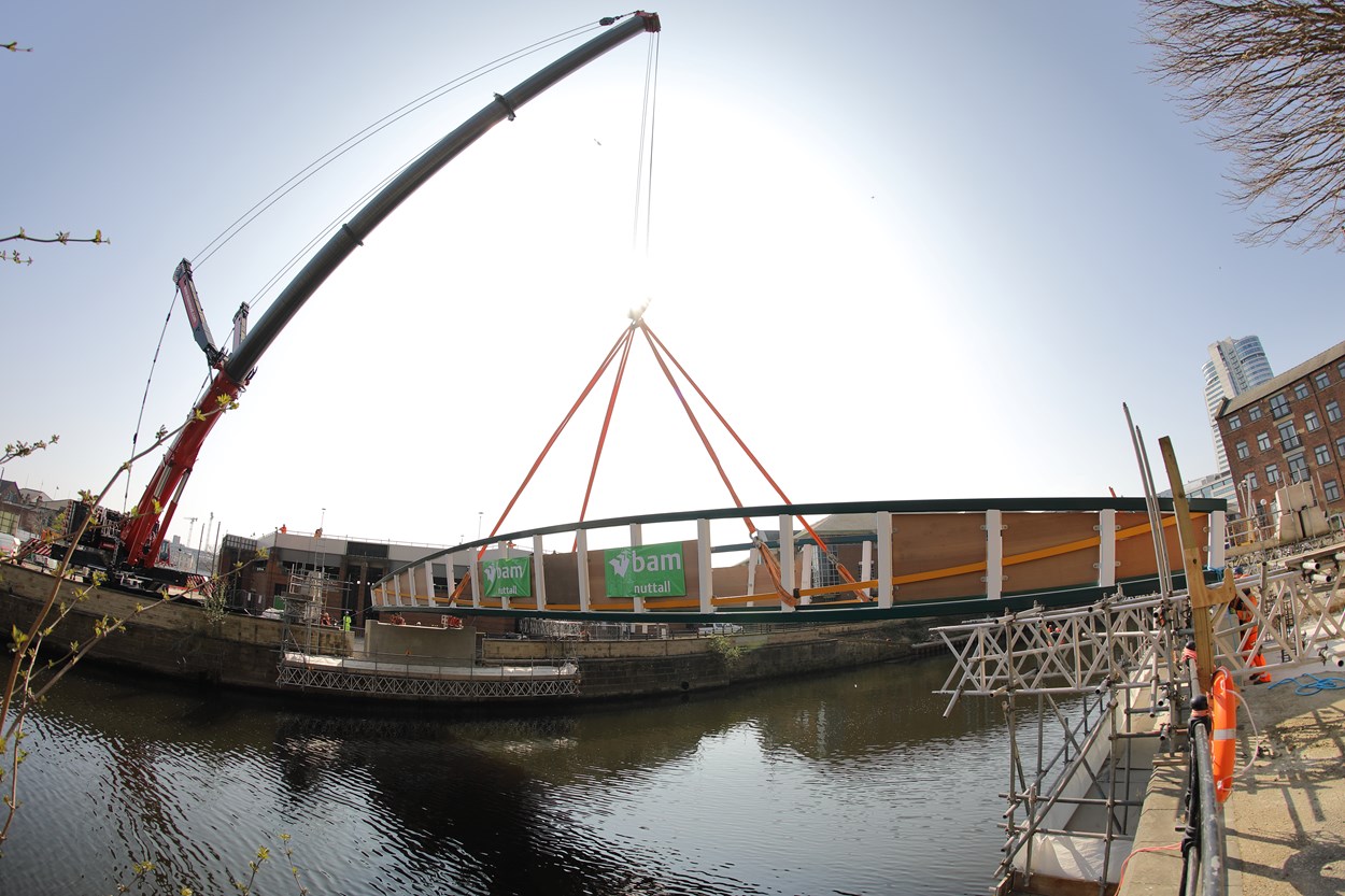 David Oluwale bridge installation: The David Oluwale bridge is lifted into place over the River Aire in Leeds. Engineers working on the David Oluwale bridge completed one of the project’s major milestones over the weekend, with cranes carefully placing the 40 tonne structure over the river where it will connect Sovereign Street to Water Lane. Credit BAM Nuttall.