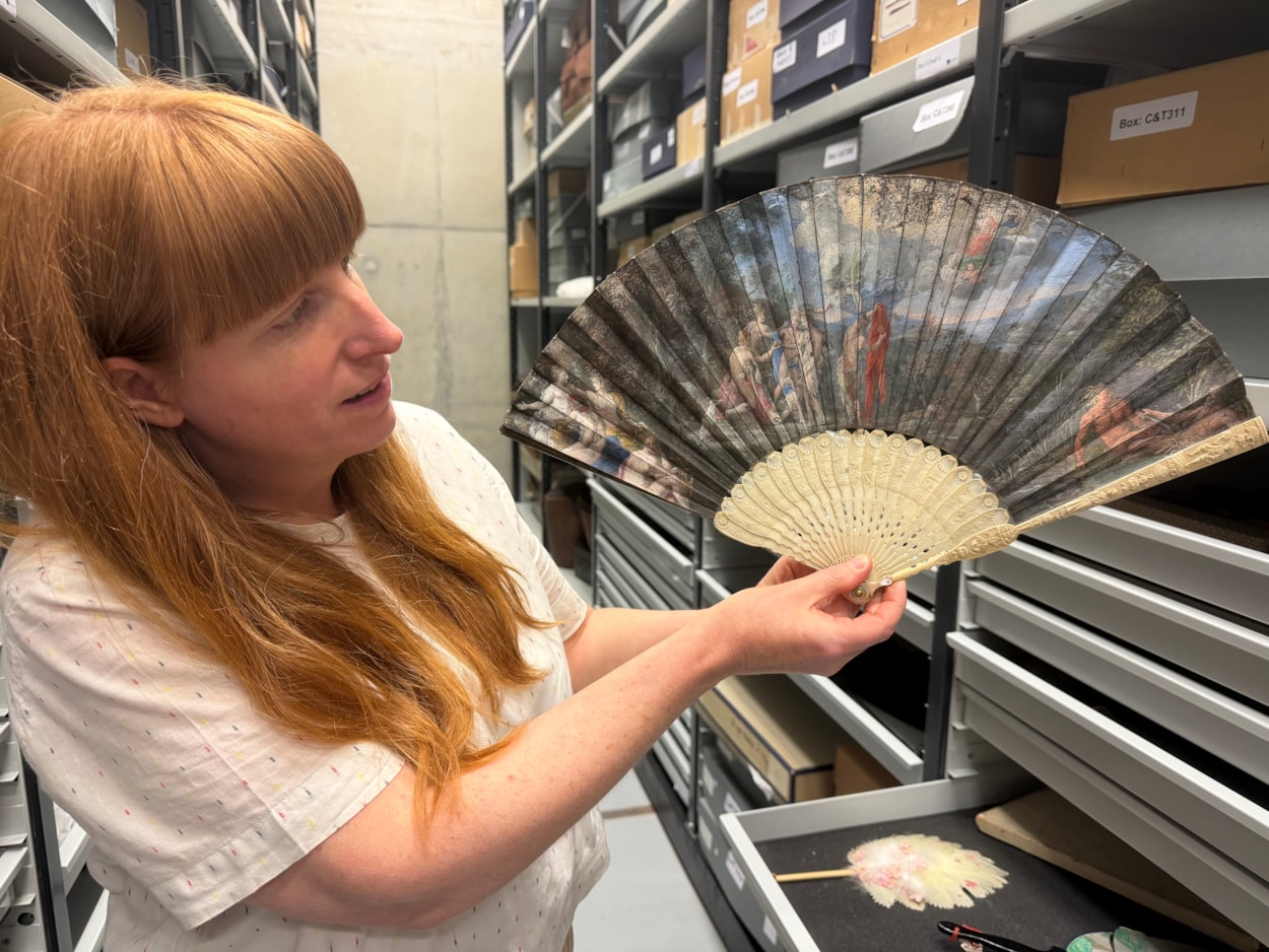 Antique fans: Curator Natalie Raw holds a stunning 350-year-old fan depicting a legendary scene from the Trojan War which is being conserved at Leeds Discovery Centre.
Crafted in around the 1680s, the beautiful folding hand fan, complete with sticks carved from antique ivory, captures The Judgement of Paris, a fateful mythical moment which saw the Trojan prince choose which of three ancient goddesses- Hera, Athena, or Aphrodite- was the most beautiful.