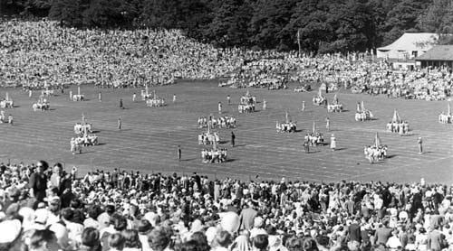 Green Libraries Week: View showing crowds of spectators watching a display of Maypole dancing at the annual Children's Day at Roundhay Park. This was a popular event, attended by schools from all over the city, which ran from 1920 until the 1960s. Children took part in physical exercise displays and dancing and a Queen was crowned each year.