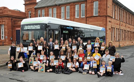 prizewinners with certificates in front of McGill's Electric bus