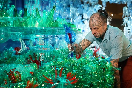 Artist George Nuku puts the finishing touches to the installation of the artwork Bottled Ocean 2123, an imagined underwater landscape made from recycled plastic. The work will go on show in the exhibition Rising Tide: Art and Environment in Oceania, which opens on August 12 at the National Museum of Scotland. Image credit: Stewart Attwood