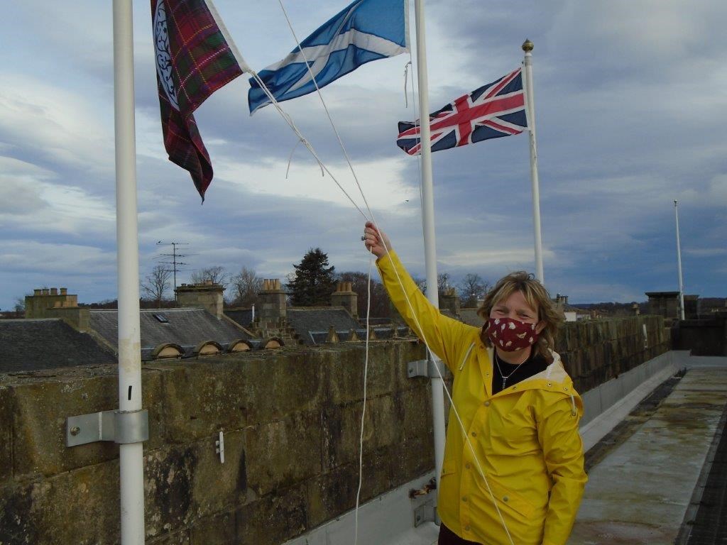 Corporate Parenting Manager, Jennifer Gordon, hoists the Care Day flag at Moray Council HQ