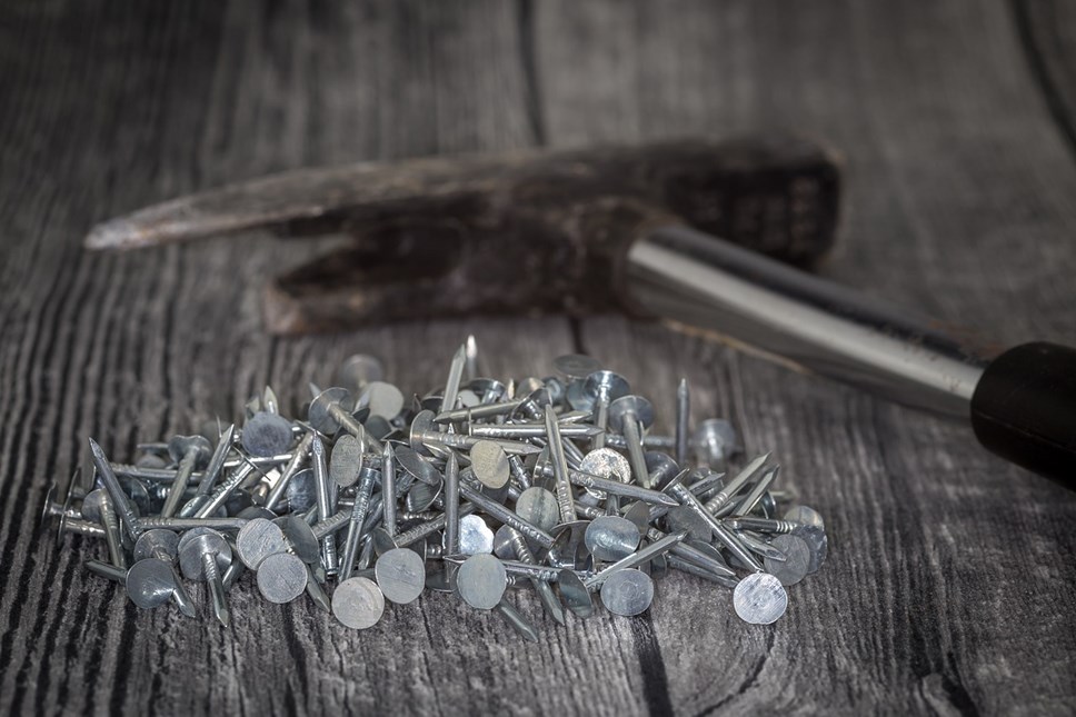 A hammer and nails used in roofing