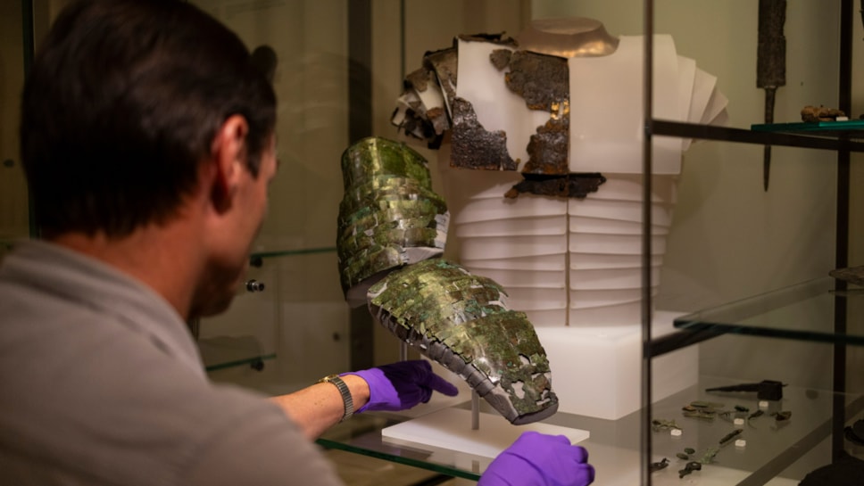 Dr Fraser Hunter installs the Roman arm guard in the Early People gallery at the National Museum of Scoltand. Image copyright Duncan McGlynn (11)