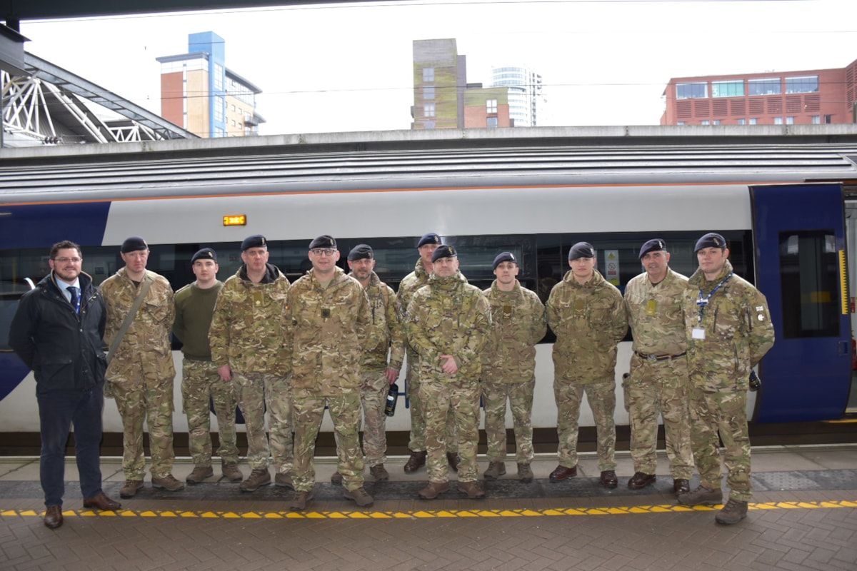 An image of Northern employees Ryan Jones and Rob Brown with military personnel at Leeds station