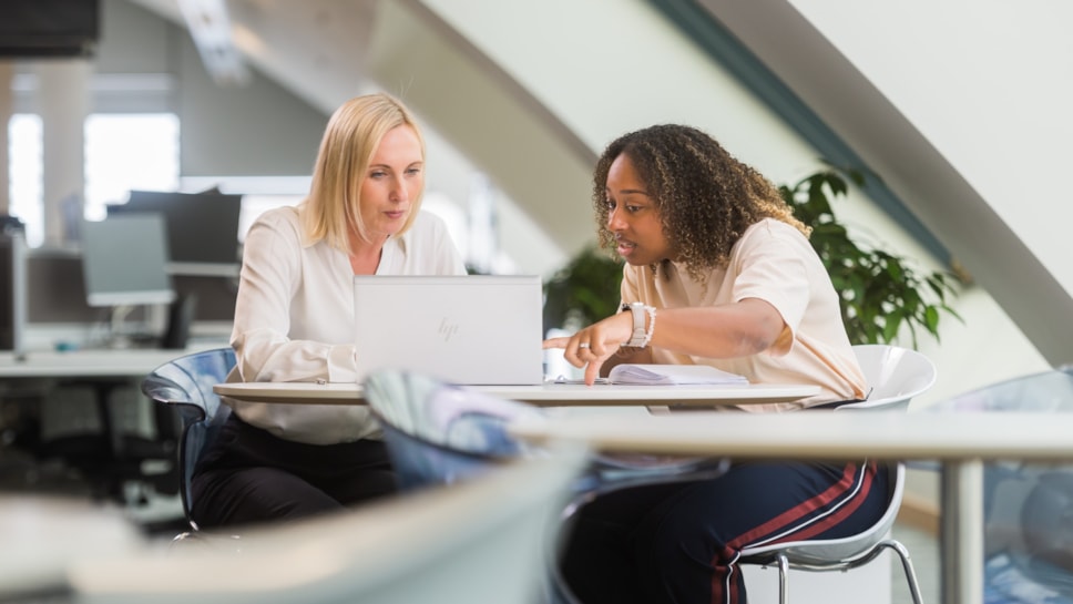 Female colleagues looking at laptop