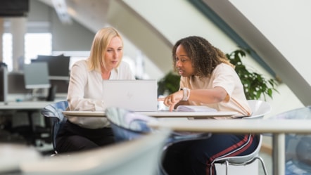 Female colleagues looking at laptop