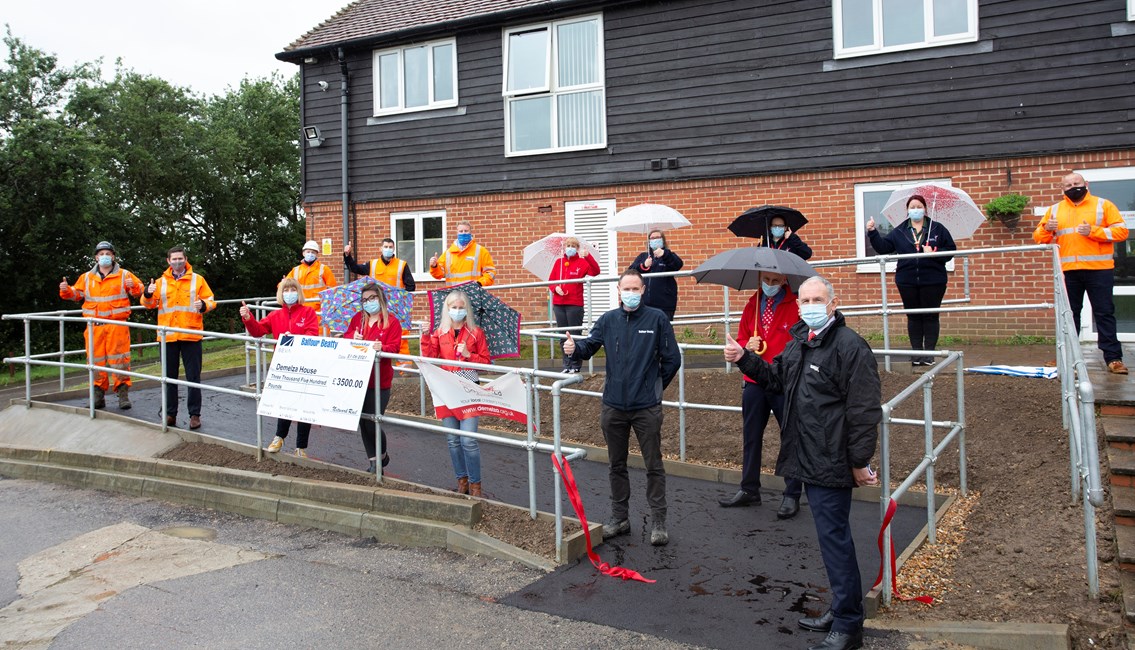 Demelza ramp: Network Rail, Balfour Beatty and Seva Rail people celebrate with Demelza Hospice Care for Children ater the completion of the new disabled ramp there.