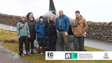 A group of scientists and students stood in front of a killer whale installation on the Shetland Isles.