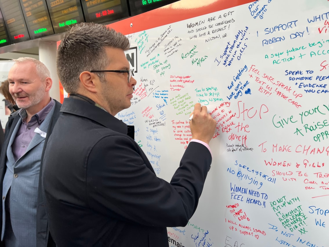 Jonny Wiseman, customer experience director for West Midlands Railway, signing the White Ribbon pledge wall