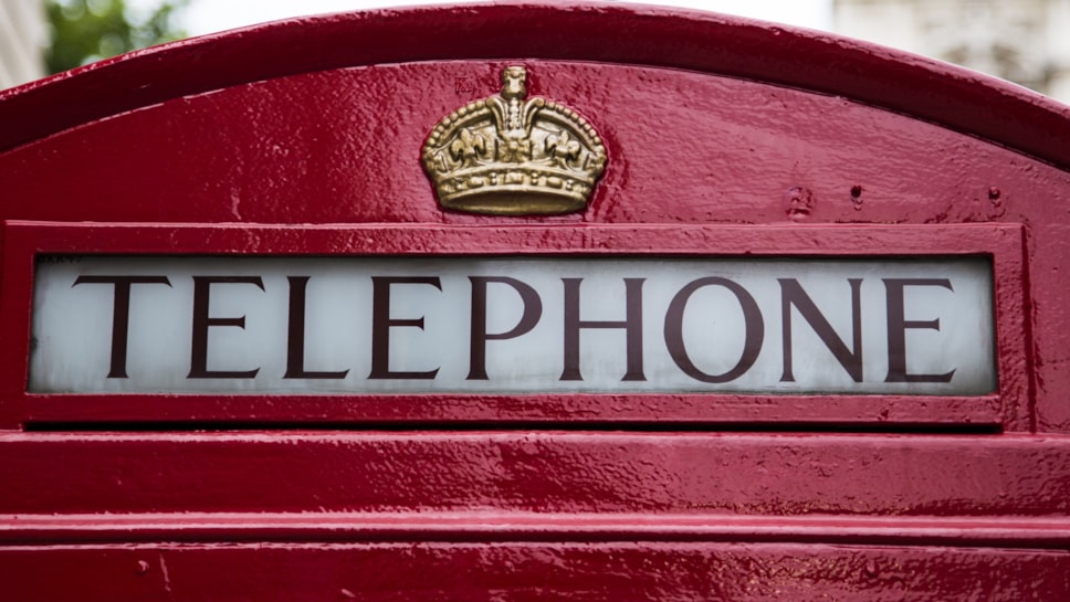 Photo of the top of a red payphone.