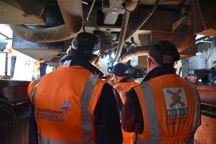 Industry colleagues looking underneath the train at the new technolgy