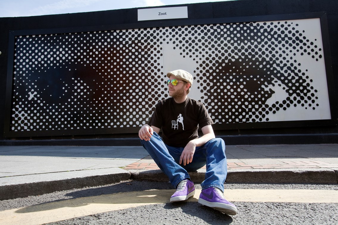 Artist Zoot: Artist Zoot with his black and white installation on display near Birmigham New Street station. The location on Hill Street was previously a bare, uninspiring wall covered in green mould. After an approach from Regenerated and Birmingham City Council, Network Rail has worked with local artists and students from King Edward VI Sheldon Heath Academy to transform the space into a showcase for local artistic talent.