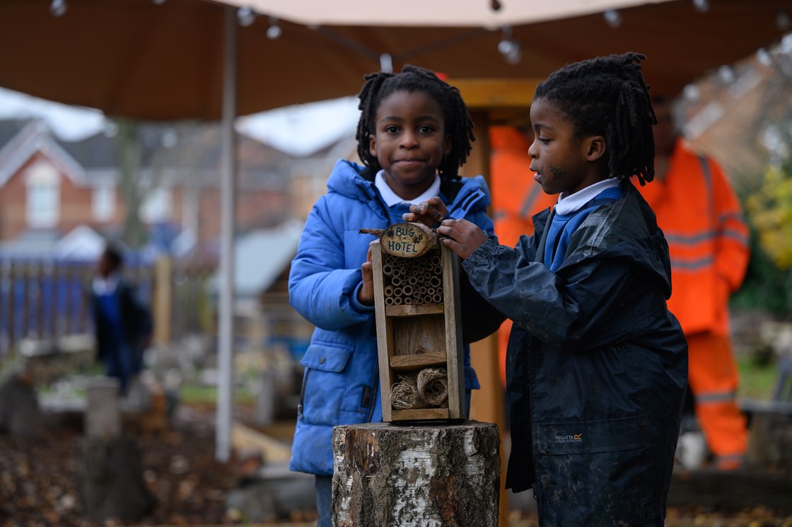Pupils with a bug hotel in the new Forest School