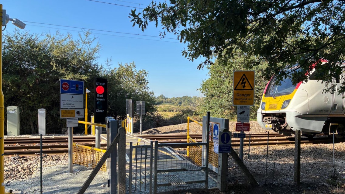 Safety boost as two Essex level crossings upgraded: Spring Lane level crossing – with newly-installed red light illuminated as a Greater Anglia train approaches