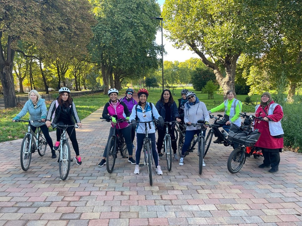 Members of the JoyRiders cycling group on their bikes, in a park