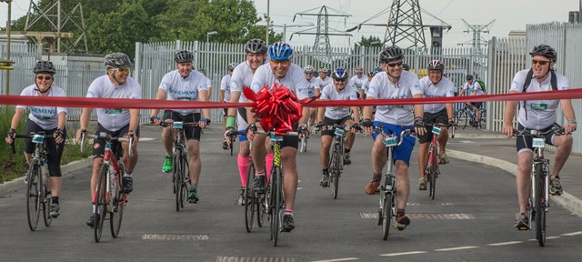 Siemens crossing-the-line-full: Staff from Siemens, the Department for Transport, Cross-London Trains and operator Govia Thameslink Railway cross the line at Three Bridges after their epic bike ride.