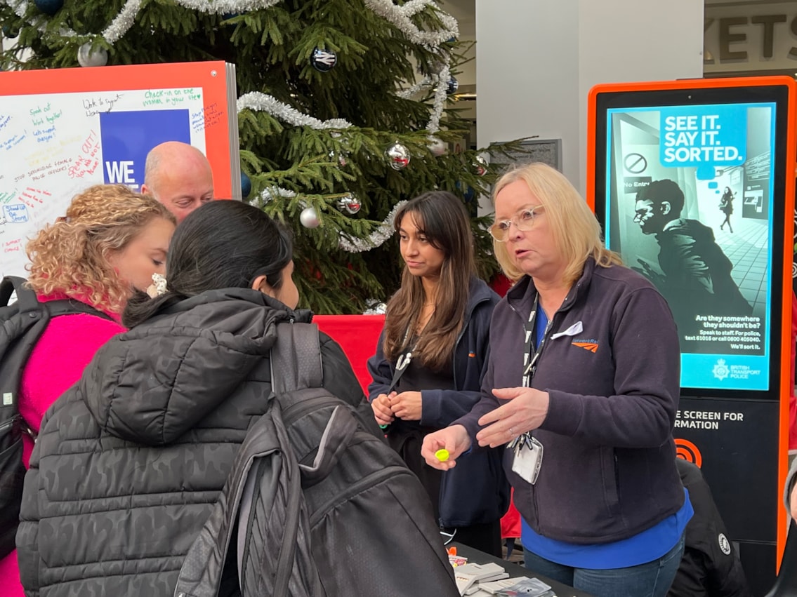Passengers at Birmingham New Street learning more about the White Ribbon campaign