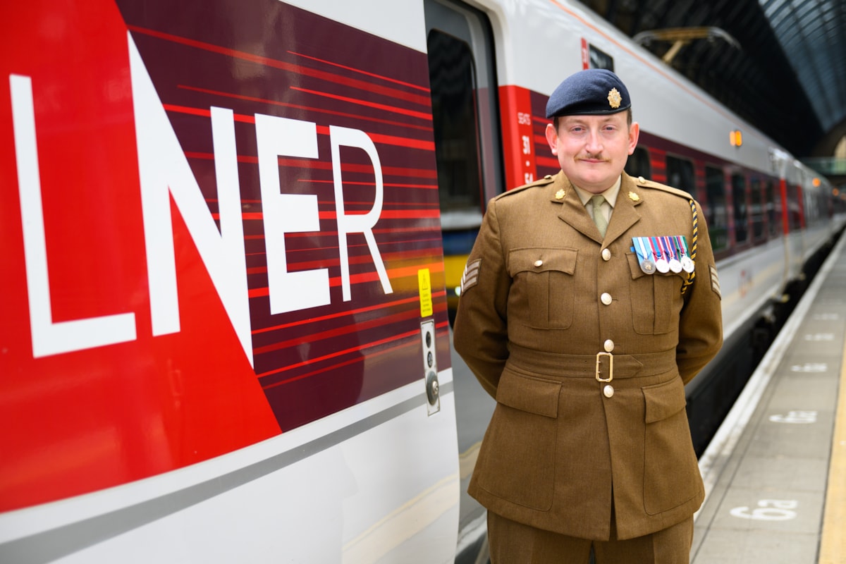 LNER driver and Army Reserve Sgt Jamie Bond stood next to an LNER Azuma