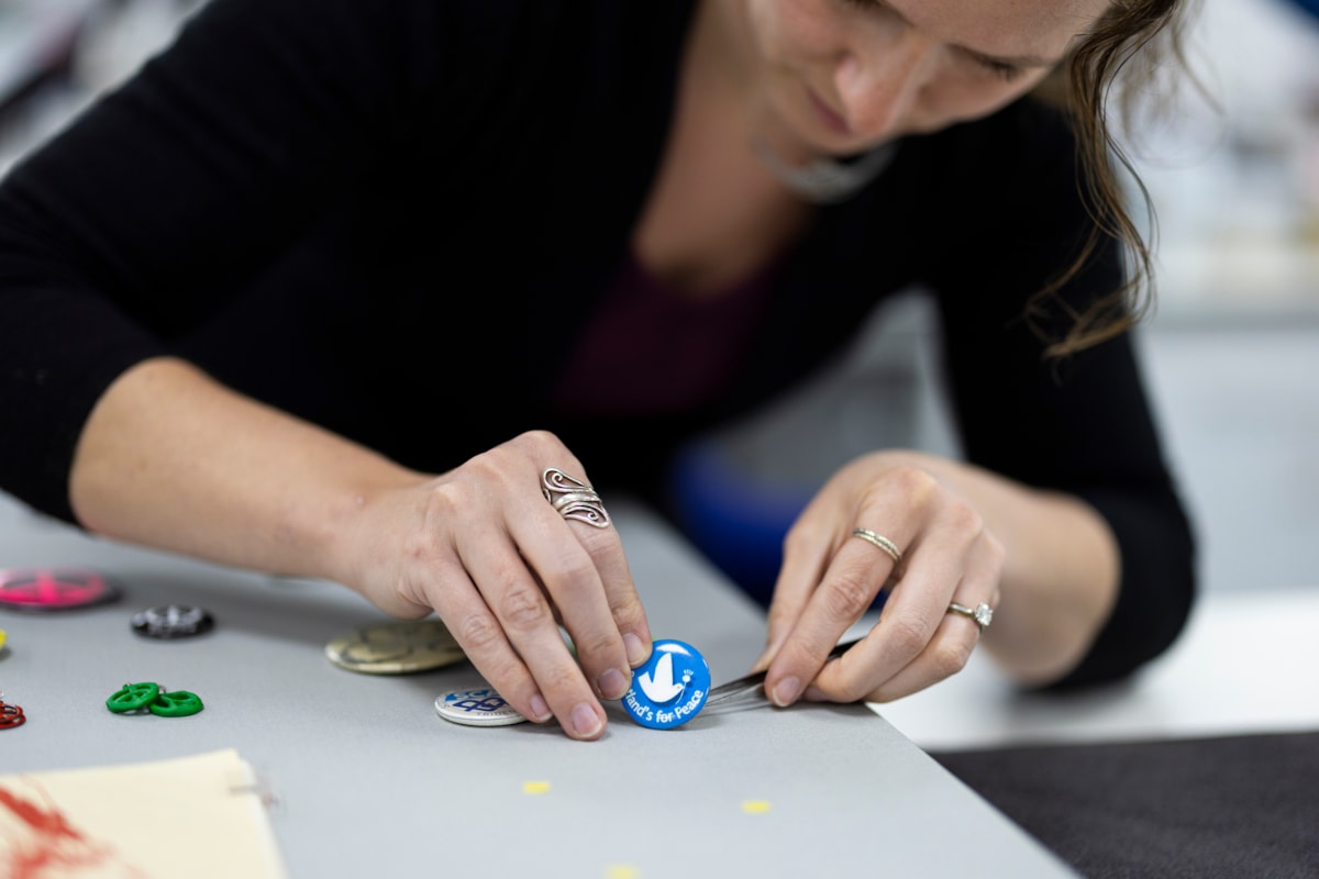 Lydia Messerschmidt, Artefact Conservator at National Museums Scotland prepares 1980s protest badges for display. Image (c) National Museums Scotland (18)